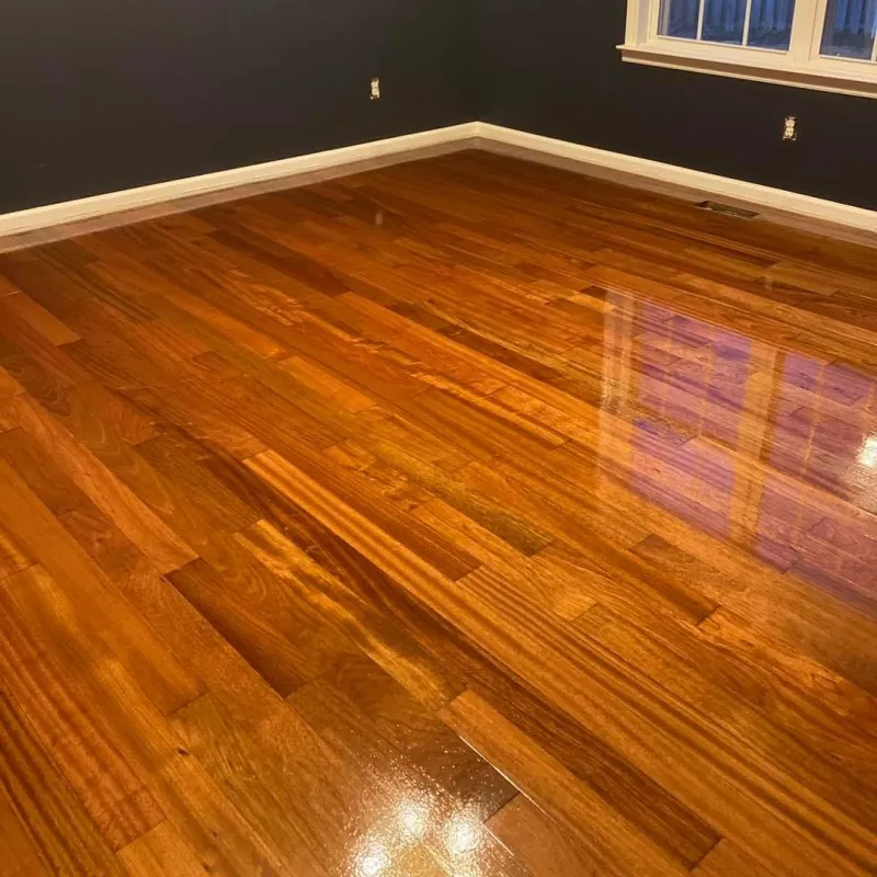 Bedroom with a high gloss amber hardwood floor reflecting the window light