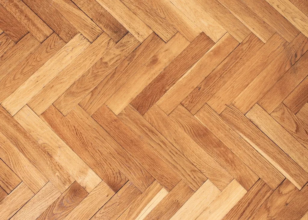 Herringbone hardwood parquet pattern in warm oak tones