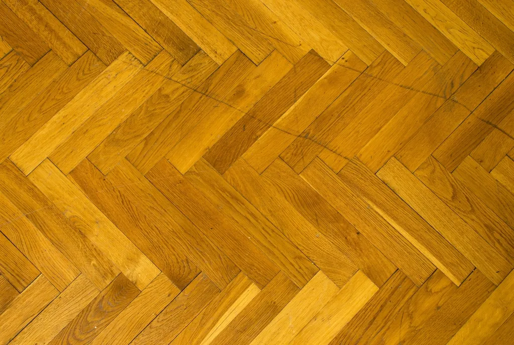 Amber herringbone hardwood pattern with a glossy finish